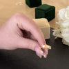Citrine ring being worn by woman’s hand, shown close-up with gift box nearby