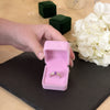 Amethyst ring being shown in a luxury pink jewelry case with flowers in background