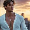 Model wearing superhero-inspired silver pendant – urban sunset setting with confident pose