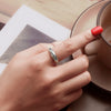 Woman wearing celestial silver ring with red nails holding a cup – lifestyle photo