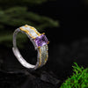 Adjustable sterling silver ring with amethyst gemstone and cubic zirconia accents on black background