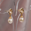 Close-up of dainty rose and pearl earrings, gold-plated floral studs with drop pearls