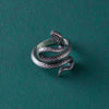 The full view of the ring against a dark background showcases its bold design and gothic style. The oxidized silver finish adds a vintage feel, while the detailed coils of the snake create a powerful impression.