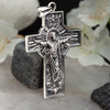 Orthodox cross pendant in 925 sterling silver placed vertically with natural lighting