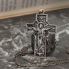 Silver cross with Christ figure lying flat, surrounded by soft white floral accents