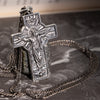 Christian resurrection cross pendant presented upright against book background and marble texture