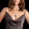 Wolf and moon medallion in sterling silver, worn on chain as spiritual and symbolic jewelry