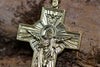 Detailed shot of Orthodox cross pendant with gold plating, capturing religious symbolism and texture