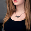 Large silver snake necklace worn by a woman – serpent pendant resting on chest as symbolic and bold jewelry