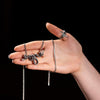 Close-up of woman holding large silver snake necklace – detailed view of handcrafted serpent pendant design