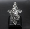 Detailed close-up of religious cross pendant with praying hands and thorn design