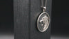 Close-up video of silver wolf pendant necklace with textured background, showing detailed craftsmanship and bold design for animal lovers